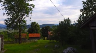 Dağlardaki küçük bir köyün altın bir günbatımında havadan çekilmiş görüntüsü.