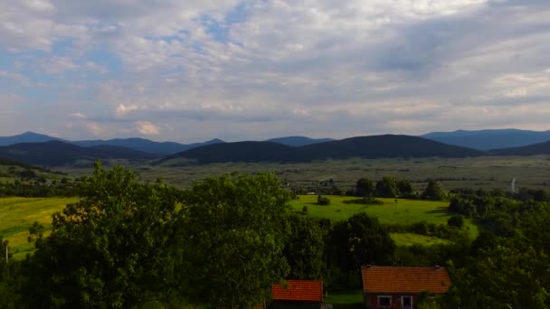 黄金の夕日の山の中で小さな農村の空中ショット — ストック動画