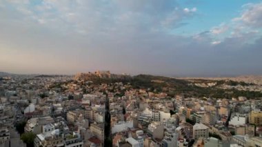 Atina, Yunanistan 'da hava manzarası, yazın gün doğumu. Altın güneş ışınlarının insansız hava aracı atışı zengin Parthenon 'u vurdu. Yunan başkentinin panorama 'sı, sakin sabah deniz arka planında üstgeçit.