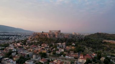 Atina, Yunanistan 'da hava manzarası, yazın gün doğumu. Altın güneş ışınlarının insansız hava aracı atışı zengin Parthenon 'u vurdu. Yunan başkentinin panorama 'sı, sakin sabah deniz arka planında üstgeçit.