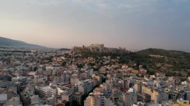 Atina, Yunanistan 'da hava manzarası, yazın gün doğumu. Altın güneş ışınlarının insansız hava aracı atışı zengin Parthenon 'u vurdu. Yunan başkentinin panorama 'sı, sakin sabah deniz arka planında üstgeçit.