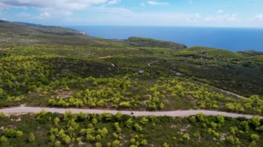 Mobiletle gezen ve arka planda deniz olan Avrupa adasını gezen genç turistlerin hava manzarası. İHA atışı