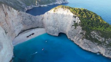 Gemi enkazı sahili, Yunanistan 'daki Navagio körfezi, Zakynthos. Sabahları insansız hava aracı geliyor. Turkuaz mavisi berrak su turistik eğlence. Küçük teknelerle güzel plajların üzerinde gün doğumu.