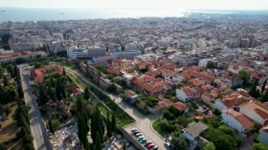 Güneşli bir günde Selanik 'in havadan görünüşü. Beyaz binalar ve insansız hava aracı atışı. Arka planda deniz olan üstgeçit çatıları. Tarihle dolu bir seyahat yeri. Şehirde yaz günü