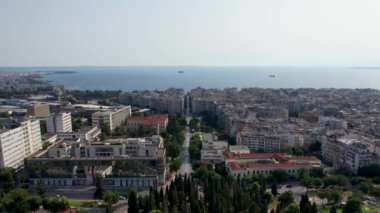 Güneşli bir günde Selanik 'in havadan görünüşü. Beyaz binalar ve insansız hava aracı atışı. Arka planda deniz olan üstgeçit çatıları. Tarihle dolu bir seyahat yeri. Şehirde yaz günü