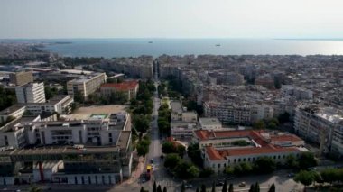 Güneşli bir günde Selanik 'in havadan görünüşü. Beyaz binalar ve insansız hava aracı atışı. Arka planda deniz olan üstgeçit çatıları. Tarihle dolu bir seyahat yeri. Şehirde yaz günü
