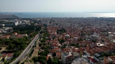 Güneşli bir günde Selanik 'in havadan görünüşü. Beyaz binalar ve insansız hava aracı atışı. Arka planda deniz olan üstgeçit çatıları. Tarihle dolu bir seyahat yeri. Şehirde yaz günü