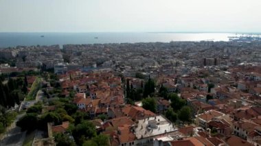 Güneşli bir günde Selanik 'in havadan görünüşü. Beyaz binalar ve insansız hava aracı atışı. Arka planda deniz olan üstgeçit çatıları. Tarihle dolu bir seyahat yeri. Şehirde yaz günü