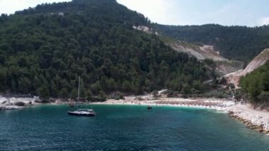 Ege Denizi 'ndeki Yunan adası Thassos' taki turkuaz sularıyla güzel Marble Sahili 'nin havadan görünüşü. Bir yaz günü beyaz kumlu berrak mavi suyun insansız hava aracı görüntüleri.