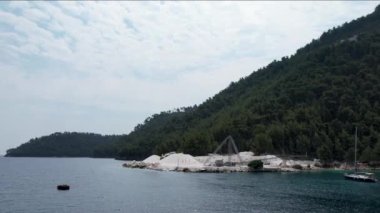 Ege Denizi 'ndeki Yunan adası Thassos' taki turkuaz sularıyla güzel Marble Sahili 'nin havadan görünüşü. Bir yaz günü beyaz kumlu berrak mavi suyun insansız hava aracı görüntüleri.