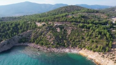 Ege Denizi 'ndeki Yunan Thassos Adası' ndaki turkuaz sularla dolu güzel ve gizli sahilin havadan görünüşü. Bir yaz günü taşlı ve kumlu berrak mavi suyun insansız hava aracı görüntüleri.