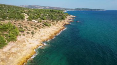 Ege Denizi 'ndeki Yunan Thassos Adası' ndaki turkuaz sularla dolu güzel ve gizli sahilin havadan görünüşü. Bir yaz günü taşlı ve kumlu berrak mavi suyun insansız hava aracı görüntüleri.