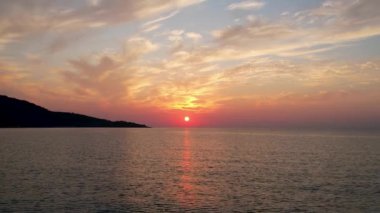 Ege Denizi 'ndeki Yunan adası Thassos' ta turkuaz sularla birlikte güzel Altın Sahilde güneşin doğuşunu gösteren hava manzarası. Bir yaz sabahında altın suyun insansız hava aracı görüntüleri. Altın saat