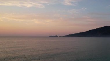 Ege Denizi 'ndeki Yunan adası Thassos' ta turkuaz sularla birlikte güzel Altın Sahilde güneşin doğuşunu gösteren hava manzarası. Bir yaz sabahında altın suyun insansız hava aracı görüntüleri. Altın saat