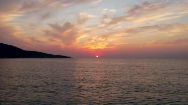 Ege Denizi 'ndeki Yunan adası Thassos' ta turkuaz sularla birlikte güzel Altın Sahilde güneşin doğuşunu gösteren hava manzarası. Bir yaz sabahında altın suyun insansız hava aracı görüntüleri. Altın saat