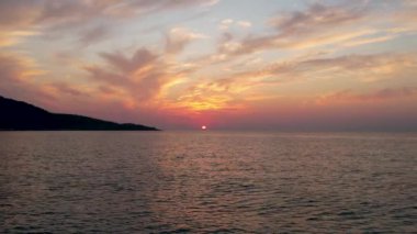 Ege Denizi 'ndeki Yunan adası Thassos' ta turkuaz sularla birlikte güzel Altın Sahilde güneşin doğuşunu gösteren hava manzarası. Bir yaz sabahında altın suyun insansız hava aracı görüntüleri. Altın saat