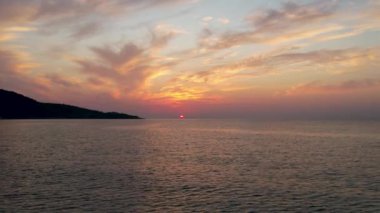 Ege Denizi 'ndeki Yunan adası Thassos' ta turkuaz sularla birlikte güzel Altın Sahilde güneşin doğuşunu gösteren hava manzarası. Bir yaz sabahında altın suyun insansız hava aracı görüntüleri. Altın saat