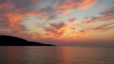 Ege Denizi 'ndeki Yunan adası Thassos' ta turkuaz sularla birlikte güzel Altın Sahilde güneşin doğuşunu gösteren hava manzarası. Bir yaz sabahında altın suyun insansız hava aracı görüntüleri. Altın saat