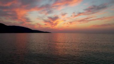 Ege Denizi 'ndeki Yunan adası Thassos' ta turkuaz sularla birlikte güzel Altın Sahilde güneşin doğuşunu gösteren hava manzarası. Bir yaz sabahında altın suyun insansız hava aracı görüntüleri. Altın saat