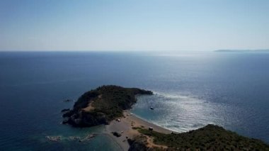 Avrupa 'nın Grece kentinde yeşil ağaçlı Sithonia yarımadasındaki mavi deniz suyunun havadan görünüşü. Pelerinin drone görüntüsü