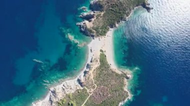 Avrupa 'nın Grece kentinde yeşil ağaçlı Sithonia yarımadasındaki mavi deniz suyunun havadan görünüşü. Pelerinin drone görüntüsü