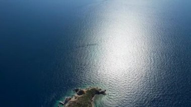 Avrupa 'nın Grece kentinde yeşil ağaçlı Sithonia yarımadasındaki mavi deniz suyunun havadan görünüşü. Pelerinin drone görüntüsü