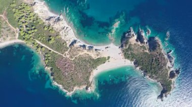 Avrupa 'nın Grece kentinde yeşil ağaçlı Sithonia yarımadasındaki mavi deniz suyunun havadan görünüşü. Pelerinin drone görüntüsü