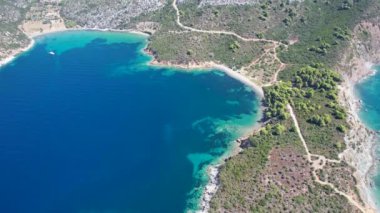 Avrupa 'nın Grece kentinde yeşil ağaçlı Sithonia yarımadasındaki mavi deniz suyunun havadan görünüşü. Pelerinin drone görüntüsü