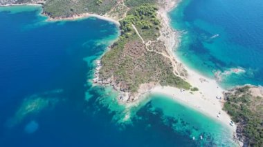 Avrupa 'nın Grece kentinde yeşil ağaçlı Sithonia yarımadasındaki mavi deniz suyunun havadan görünüşü. Pelerinin drone görüntüsü