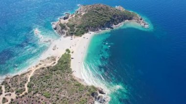 Avrupa 'nın Grece kentinde yeşil ağaçlı Sithonia yarımadasındaki mavi deniz suyunun havadan görünüşü. Pelerinin drone görüntüsü