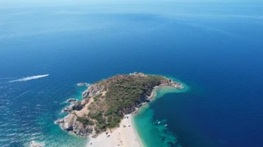 Avrupa 'nın Grece kentinde yeşil ağaçlı Sithonia yarımadasındaki mavi deniz suyunun havadan görünüşü. Pelerinin drone görüntüsü