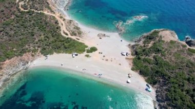 Avrupa 'nın Grece kentinde yeşil ağaçlı Sithonia yarımadasındaki mavi deniz suyunun havadan görünüşü. Pelerinin drone görüntüsü