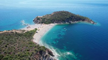 Avrupa 'nın Grece kentinde yeşil ağaçlı Sithonia yarımadasındaki mavi deniz suyunun havadan görünüşü. Pelerinin drone görüntüsü