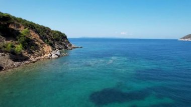 Avrupa 'nın Grece kentinde yeşil ağaçlı Sithonia yarımadasındaki mavi deniz suyunun havadan görünüşü. Pelerinin drone görüntüsü