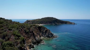 Avrupa 'nın Grece kentinde yeşil ağaçlı Sithonia yarımadasındaki mavi deniz suyunun havadan görünüşü. Pelerinin drone görüntüsü