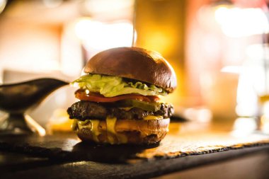 Kafe arka planında bulanık bir burger. Etli hamburger.