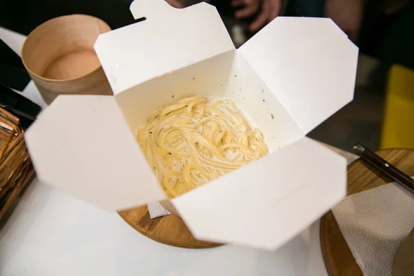 Pasta in a cardboard box. Spaghetti with sauce