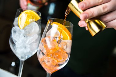 Barmen kokteyl yapar. Şişeden alkol dökülüyor. Buz kokteyli