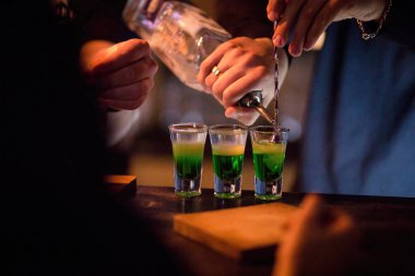 Barmen alkollü içeceklerle kokteyl hazırlıyor.