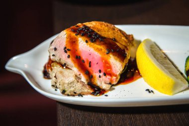 Beyaz tabakta limonlu ızgara et.