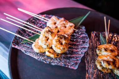 Siyah arka planda sebzeli ve soslu ızgara kalamar.