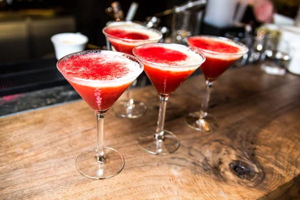 cocktail with red and green cocktails on the bar counter