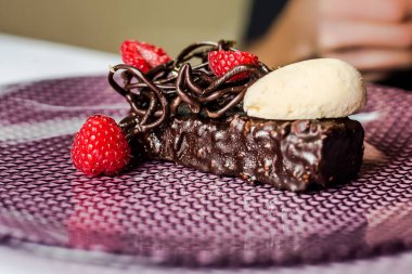 Delicious chocolate cake with raspberries and ice cream