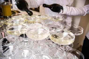 Catering. Waiters pouring champagne into wineglasses