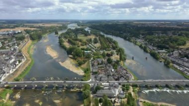 Pont du Marechal Leclerc 'in Loire nehri üzerindeki araba trafiğinin hava aracı görüntüleri. Güneşli bir gün, dalgalar, adanın yeşil manzarası, manzaranın iki tarafı arasında. Amboise Köprüsü. HD görüntüler