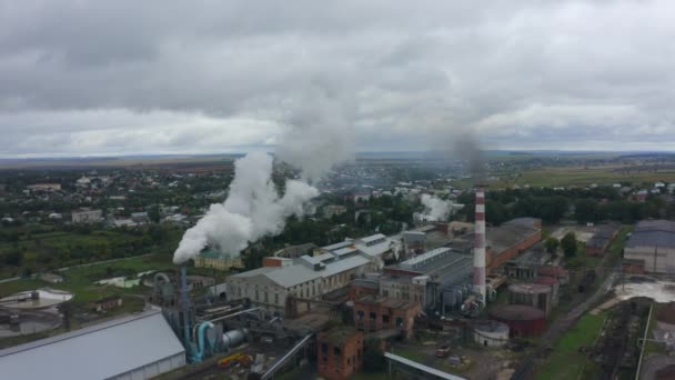 一个烟囱冒着浓烟的工厂在附近的一个城市里抛撒空气和环境的无人机镜头 高质量的4K镜头 — 图库视频影像