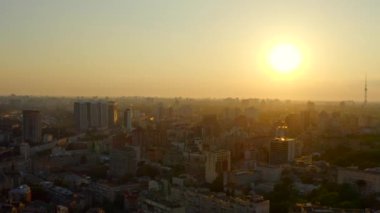 Şehrin batan güneşin altın ışıklarındaki 4K hava görüntüsü. Parlak ışıktan parlayan evlerde. Modern ve geçmişin eklektik mimarisi. Savaştan önce yaz Kyiv. Ukrayna 'nın güzel başkenti