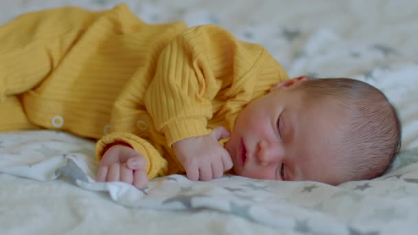 Filmmaterial Kleines Süßes Neugeborenes Gelben Overall Liegt Ruhig Auf Der — Stockvideo