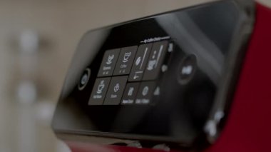 Otomatik kırmızı kahve makinesinde kahve yaparken çekilmiş 4K 'lık yüksek kaliteli yakın çekim görüntüler. Parmak, kahve düğmesine ve çalma tuşuna basar. Ofis mutfağında kahve molası zamanı. 