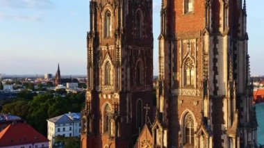 Gün batımında St. Johns Katedrali 'ne yakın 4K hava görüntüleri. Modern turist kasabasının ortasında çarpıcı gotik mimari. Altın ışıkta kuleler. Avrupa kenti Wroclaw, Polonya. Oder Nehri